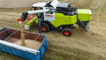 Новый зерноуборочный комбайн CLAAS EVION на разгрузке зерна из зернового бункера