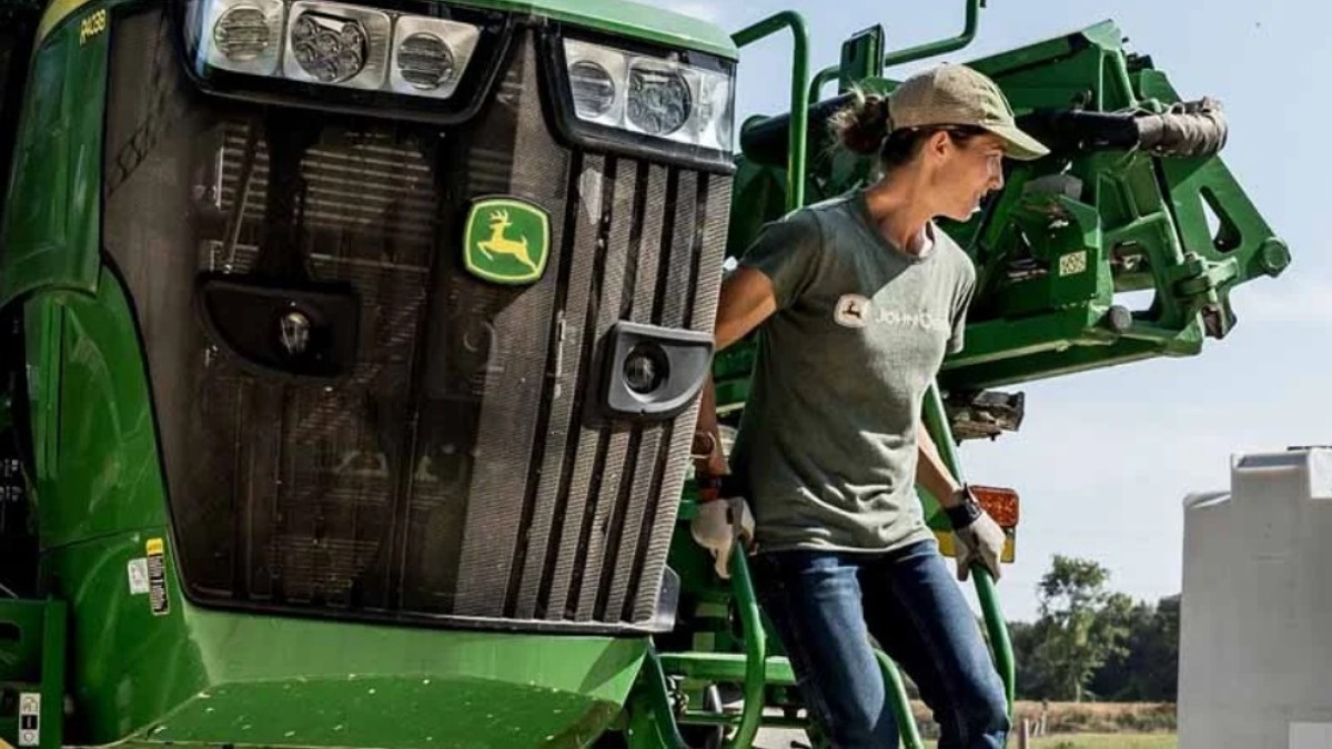 Женщина-механизатор у сельхозтехники John Deere (фото для иллюстрации)