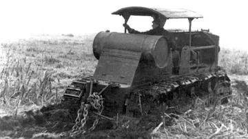 Гусеничный трактор «Коммунар» в поле, вид сзади
